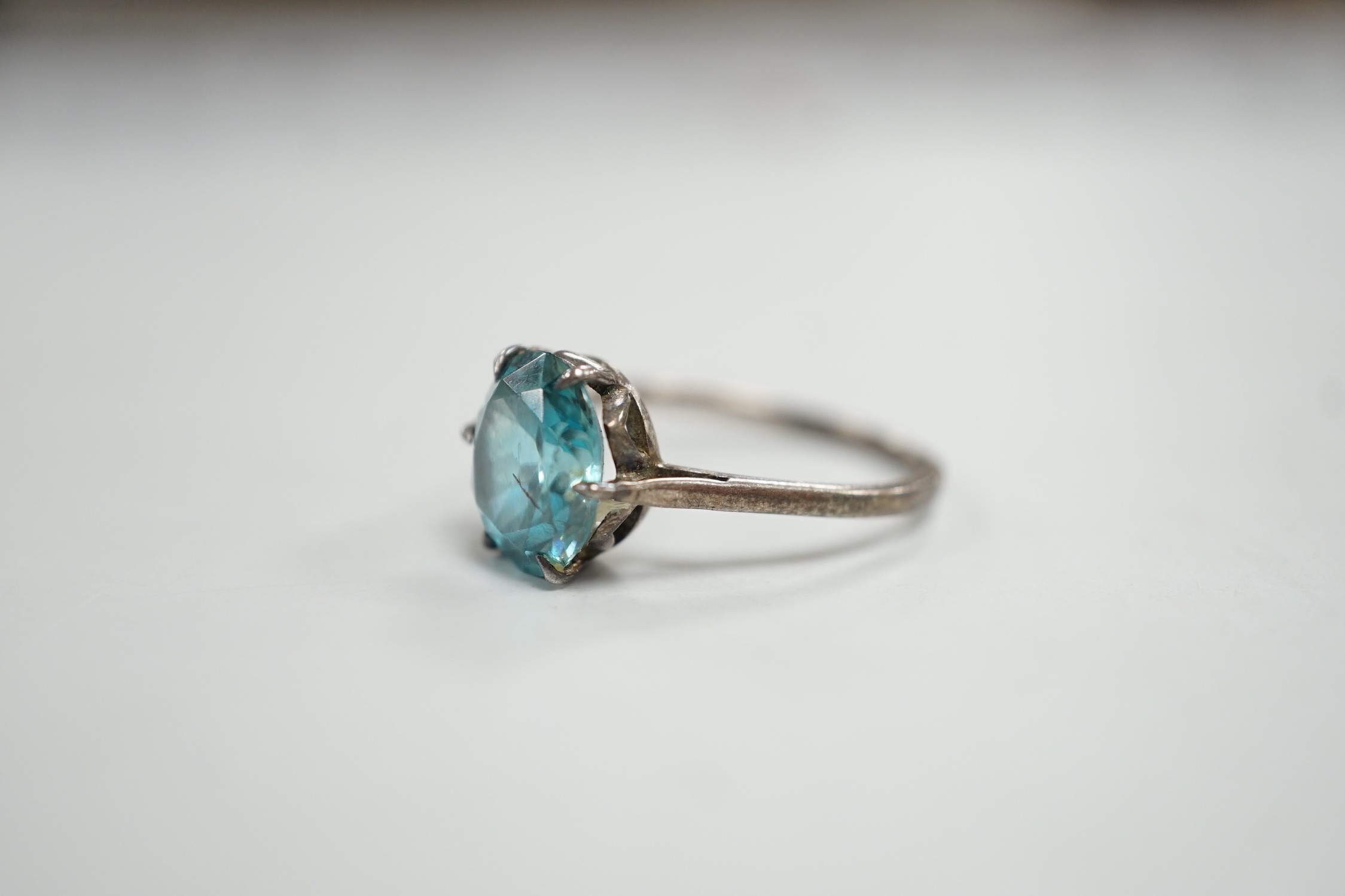 A white metal and blue zircon set ring, size P/Q, gross weight 2.8 grams.
